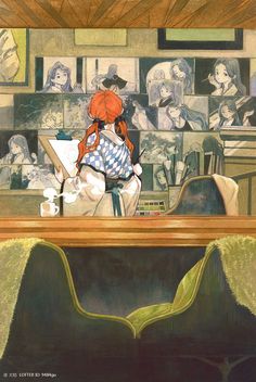 a woman sitting at a table with an umbrella over her head and many pictures on the wall behind her