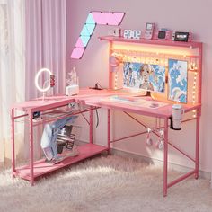 a pink desk topped with a computer monitor next to a window filled with curtains and lights