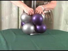 a person is holding some balls on top of a table with a green cloth around it