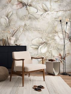 a living room with floral wallpaper and a chair in front of a rug on the floor