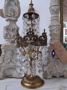 a gold and crystal candelabra on display in front of a mirror with a price tag