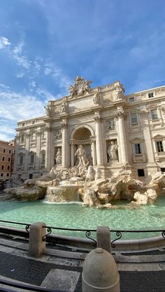 an ornate building with fountains in front of it