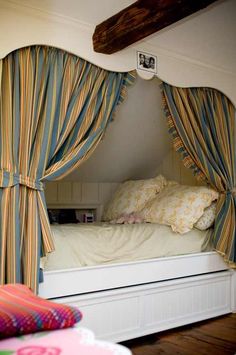 an image of a bed with curtains on the top and bottom side, in front of a window