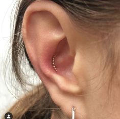 a close up of a person's ear with two small hoops attached to it