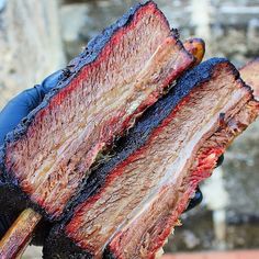 a person holding a large piece of meat on top of it's grilling tongs