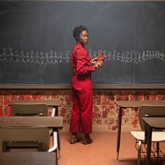 a woman standing in front of a blackboard