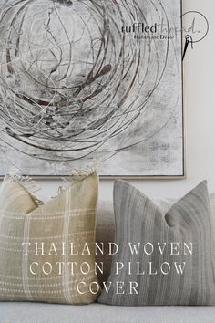 three pillows sitting on top of a couch next to a painting and the words thailand woven cotton pillow cover