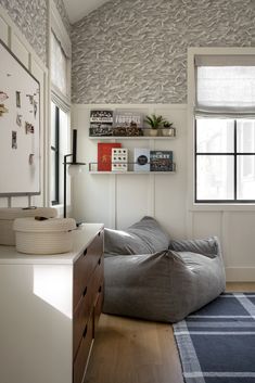 a living room with a bean bag chair in the corner and shelves on the wall