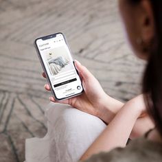 a woman is looking at the website on her phone