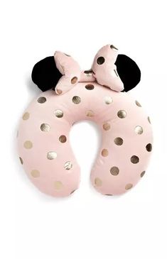 a pink and gold polka dot neck pillow with minnie mouse ears on the top,