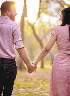 a man and woman holding hands in the park