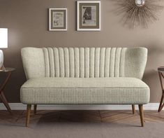 a living room scene with focus on the couch and two framed pictures hanging on the wall