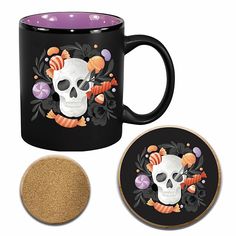 a black coffee mug with a skull and flowers on it next to a cork coaster