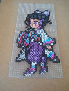 an image of a woman made out of perler beads on a counter top,