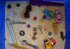 various toys and tools are laid out on the floor in front of a blue plastic bag