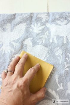 a person with their hand on a yellow piece of paper