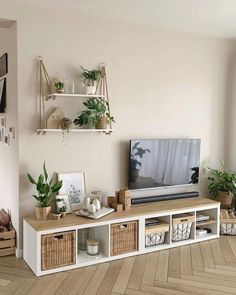 a flat screen tv sitting on top of a wooden shelf