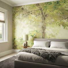 a bedroom with a large tree painted on the wall next to a bed and window