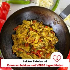 a pan filled with food sitting on top of a table next to peppers and other vegetables