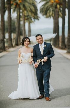 a bride and groom are walking down the street