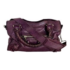 This is a wonderful Balenciaga City bag in purple lambskin. An iconic style year after year.  Features include: Silver-colored hardware and leather-covered metal studs 2-way zip top closure Rolled top handles with leather whipstitched detail  Detachable and adjustable shoulder strap Buttery lambskin with decorative perforated edging throughout The interior is lined with protective black cotton, and it has a one-zip storage pocket Purple Balenciaga Bag, Balenciaga Large Bag, Balenciaga Classic City Bag, Balenciaga Bag Silver, Purple Balenciaga City Bag, City Bag, Purple Leather, Iconic Style, Balenciaga City Bag