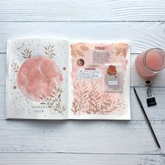 an open book with watercolors and ink on it next to a cup of coffee