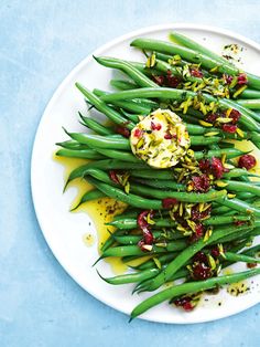 a white plate topped with green beans and cranberries