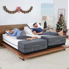 two people laying on top of mattresses in a living room next to the ocean