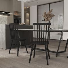 two black chairs sitting at a table in a kitchen next to a stove and oven