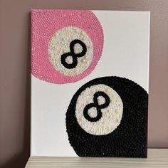 an image of two balls painted on canvas with bead work in black and white