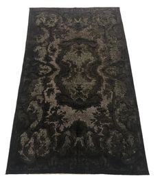 a black and gray rug with an intricate design on the bottom, in front of a white background