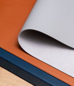 three different colors of leather on top of each other, one is blue and the other is orange