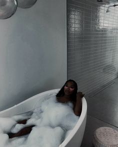 a woman sitting in a bathtub filled with foam