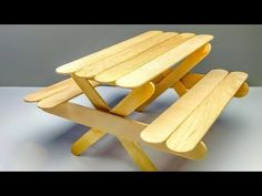 two wooden benches sitting next to each other on top of a white table with grey background