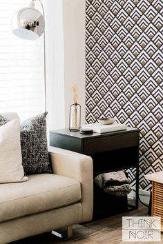 a white couch sitting next to a black table in a living room on top of a hard wood floor