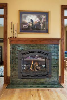 a living room with a fire place in the center and a painting on the wall