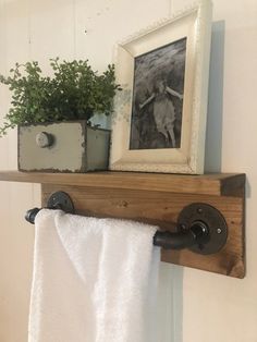 a towel rack with a potted plant on top of it and a framed photo