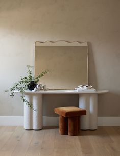 a table with a mirror and stool in front of it