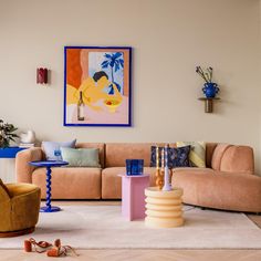 a living room filled with lots of furniture next to a painting on the wall over a coffee table