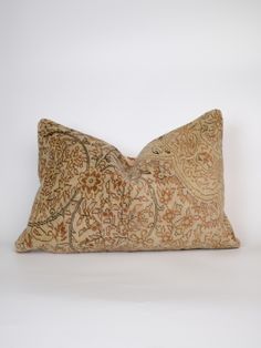 a decorative pillow with an intricate design on the front and back, sitting against a white background