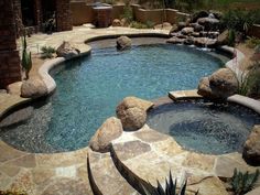 an outdoor swimming pool with rocks and water features