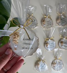 a hand holding a bag filled with small cookies next to some leaves and other packaged items