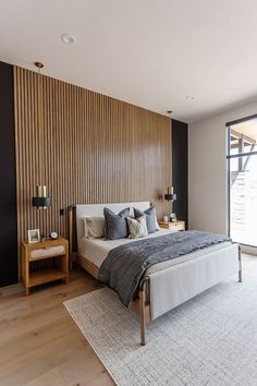 a large bed sitting next to a window in a bedroom on top of a hard wood floor