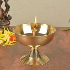 a small metal bowl with a candle in it