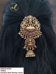 the headpiece is adorned with gold and pink stones, including an intricately decorated brooch