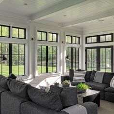 a living room filled with furniture and lots of windows