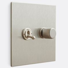 a close up of a light switch on a white wall with two knobs and an outlet