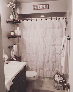 a bathroom with a white shower curtain next to a toilet