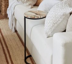 a white couch sitting next to a table on top of a rug