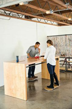 a man and woman standing in front of a desk